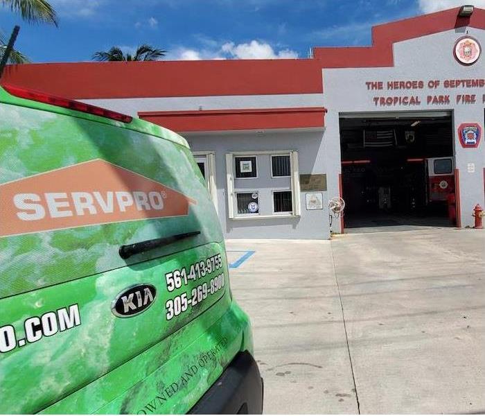 Back of a SERVPRO car in front of a fire station